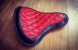 Vintage leren bobberzadel met rood ruitpatroon - custom motorfiets