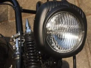 Vintage black bobber motorcycle headlight with white optics