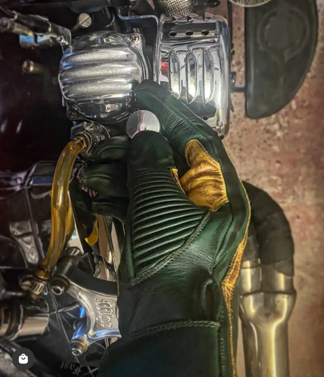 Hold Fast 1971 Le Mans Motorradhandschuh, patiniertes Grün, wird am Lenker getragen, mit kontrastierender Handfläche und gefaltetem Handgelenk.