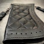 Portefeuille cuir chaîne biker vu de trois quarts, matelassage losange et bordure perforée
