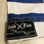 Étiquette Hold Fast cousue sur le revers du pantalon en denim bleu et blanc
